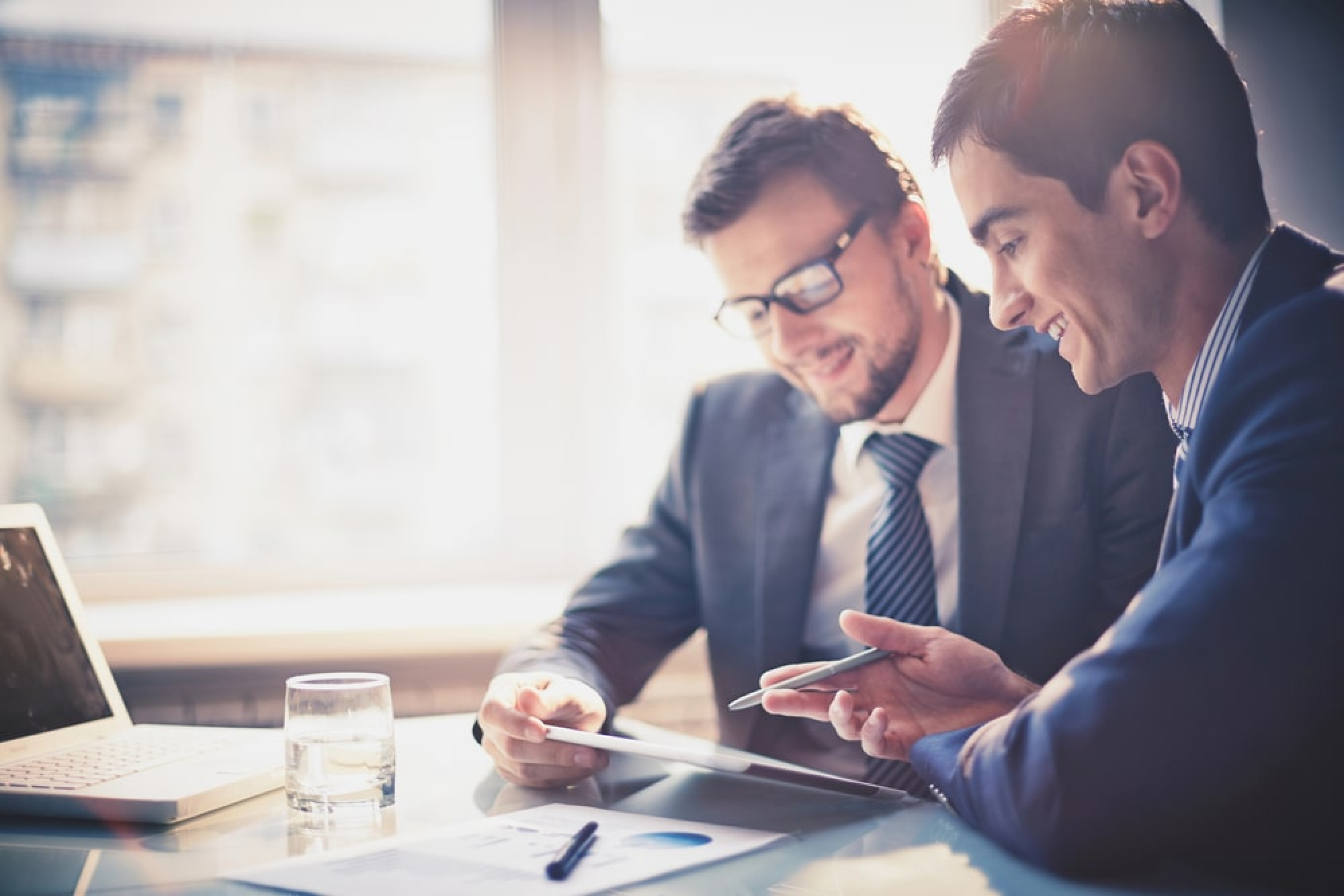 2 businessmen discussing business lending at a desk.